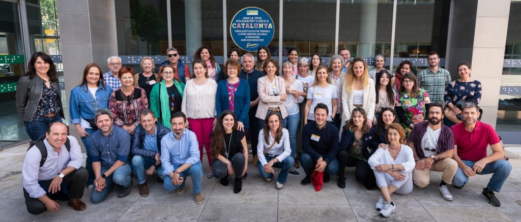 Participantes en el seminario del proyecto de acceso vital en Barcelona posan delante de un edificio.