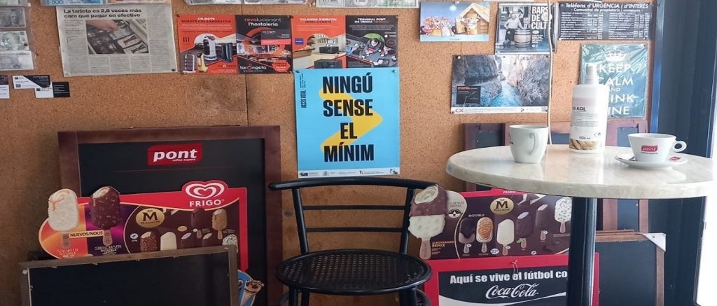 Cartel del proyecto Acceso Vital pegado en el interior de una cafetería.